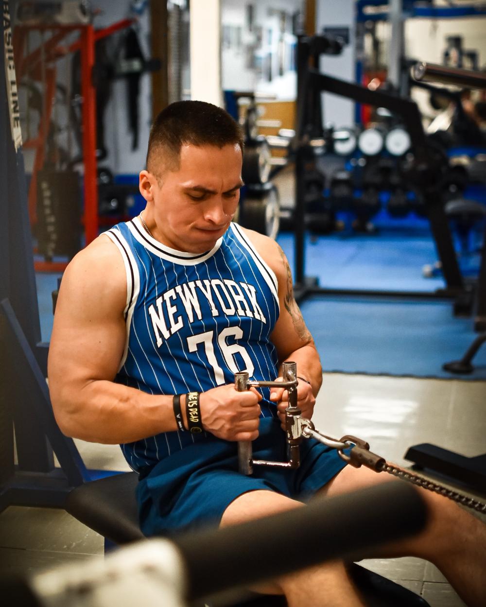 Eddie Torres haciendo press de banca en el rack azul